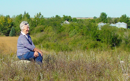 Naomi Schindele sitting on Butte overlooking the farm where she was born